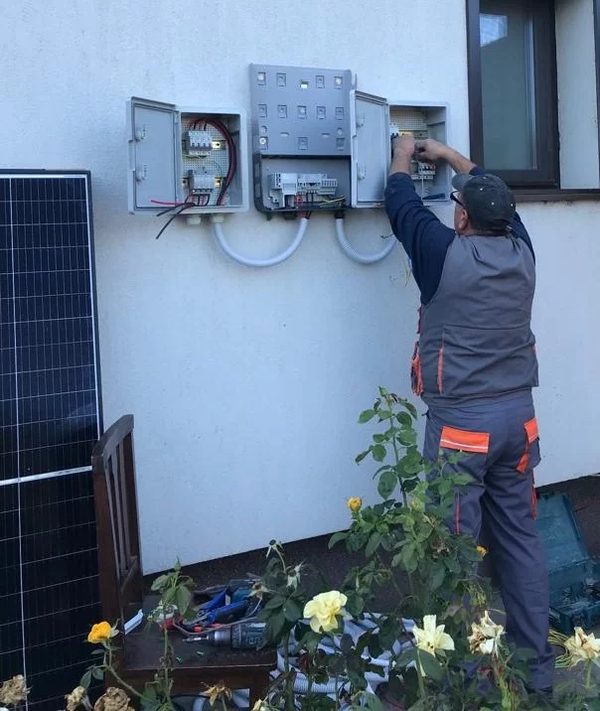 Electrician Solarsis lucrând la invertor și la tabloul electric